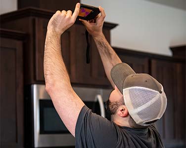 Adrian Phillips performing a buyer's home inspection with a thermal imaging camera.